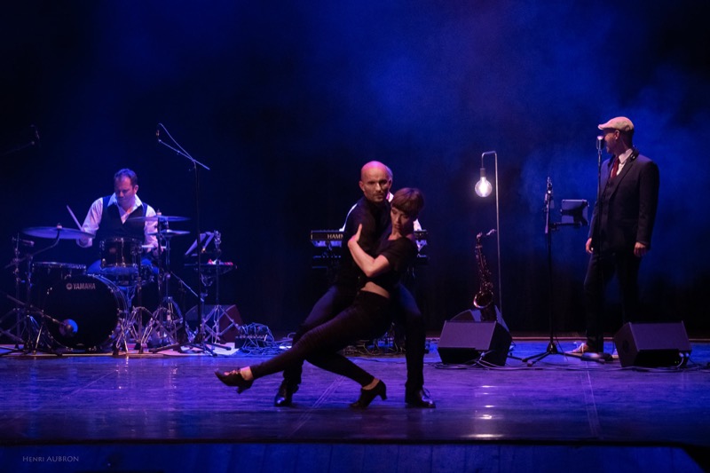 Les deux danseurs et le trio de musiciens sous une lumière bleue