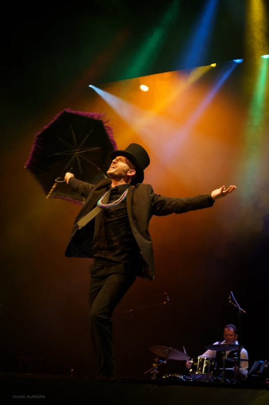 Danseur au parapluie sous les projecteurs colorés