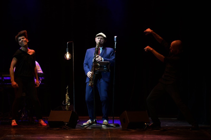 Le saxophoniste au centre du plateau, les danseurs de part et d'autre