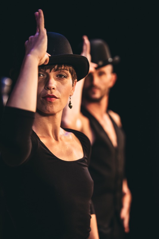 Les artistes alignés, chapeaux melon, avant le tableau suivant