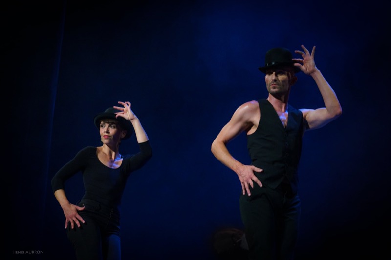 Duo de danseurs synchronisés, mains au chapeau